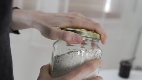Slow-motion-shot-as-opening-a-jar-full-with-white-powder,-flour,-gluten-free-baking