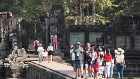 Mittlere-Aufnahme-Von-Touristen,-Die-Einen-Tempel-Auf-Dem-Gehweg-In-Angkor-Wat-Verlassen