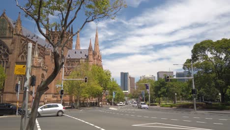 St.-Mary-Cathedral-Von-Der-Seite-Mit-Blick-Auf-Den-Verkehr-Von-Sydney-Und-Der-Skyline-Im-Hintergrund