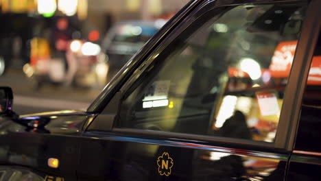 Front-closeup-shot-of-a-Black-Tokyo-Taxi-with-blurred-background