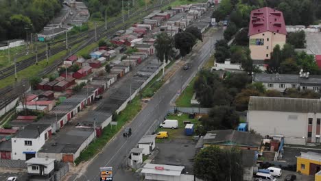 Aerial-View-of-Cars-Driving-on-Wet-Road-Near-Railroad-Tracks