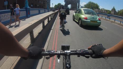 POV-Of-Cyclists-On-Tower-Bridge,-London-Going-Past-Traffic