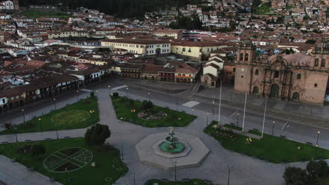 4k-aerial-footage-at-twilight-of-Plaza-de-Armas-in-Cusco-City,-Peru-during-Coronavirus-quarantine,-left-to-right-truck-and-pan-,-jib-up-and-wide-angle-shot
