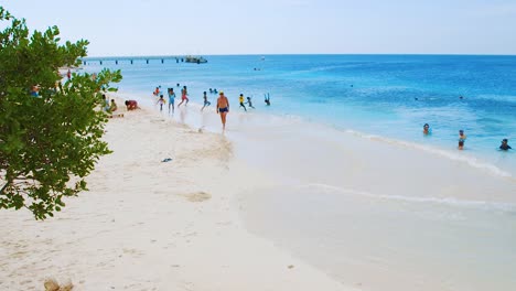 People-enjoying-the-beautiful-white-sand-Te-Amo-Beach-in-Bonaire-on-a-summer-day---wide-pan