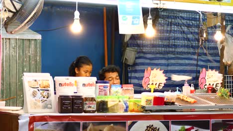 Padre-E-Hija-En-Su-Puesto-Familiar-En-Un-Mercado-Nocturno-En-Tailandia