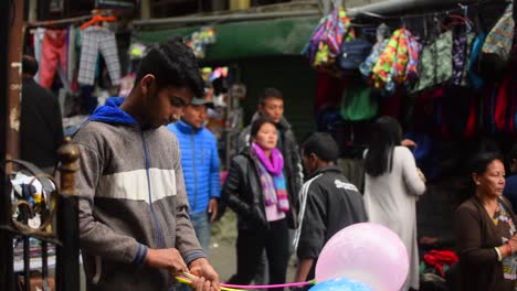 Ein-Ballonverkäufer-Bläst-Die-Ballons-Auf,-Um-Sie-In-Den-Straßen-Von-Darjeeling-Zu-Verkaufen