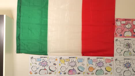 Bandera-Italiana-Colgada-En-La-Pared-De-Un-Aula-Escolar,-Inclinada-Hacia-Arriba