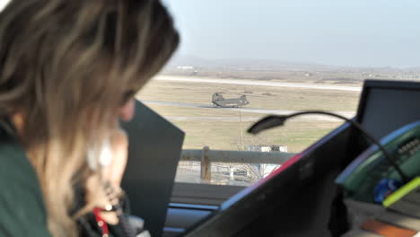 Vista-De-Un-Helicóptero-Chinook-Visto-Desde-La-Torre-Atc-Con-Una-Operadora-Caucásica-Hablando-Por-Teléfono-En-Primer-Plano