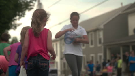 Niña-Repartiendo-Dulces-Gratis-A-Los-Niños-En-El-Desfile,-Cámara-Lenta