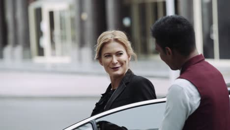 Rich-Businesswoman-Steps-Out-Of-The-Car-As-Chauffeur-Opens-The-Door---close-up,-slow-motion