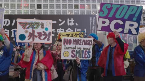 Personas-Disfrazadas-Con-Pancartas-Que-Protestan-Contra-El-Uso-De-Máscaras-Y-Pruebas-De-Pcr-En-Shibuya-En-La-Noche-De-Halloween-En-Tokio,-Japón