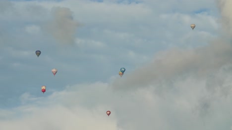Sieben-Kleine-Heißluftballons-Stehen-Hoch-Am-Himmel-Zwischen-Den-Wolken