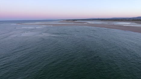 Ruhige-Wellen-Rollen-Während-Des-Sonnenuntergangs-In-Praia,-Portugal,-In-Richtung-Eines-Wunderschönen-Strandes