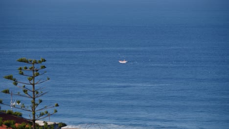 Far-away-fishing-boat-in-deep-blue-ocean