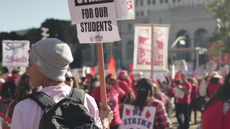 Man-with-Supreme-Beanie-Holds-Sign,-On-Strike-For-Our-Students,-LAUSD-Teacher's-Strike