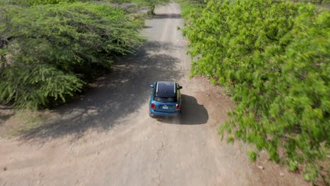 Aerial-view-of-a-blue-colored-mini-Cooper-road-chase-on-a-tropical-island