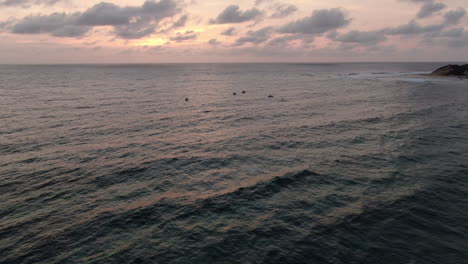 Tilt-Up-Aerial-View-of-Indian-Ocean-Surface-Under-Sunrise-Sunlight,-Drone-Shot