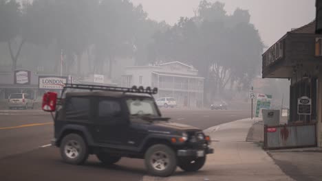 Los-Vehículos-Viajan-A-Través-De-La-Calle-Humeante-En-La-Ciudad-Rural,-Creek-Fire,-California