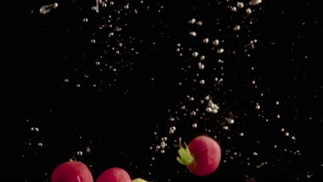 Radishes-Falling-into-Water-Super-Slowmotion,-Black-Background,-lots-of-Air-Bubbles,-4k240fps