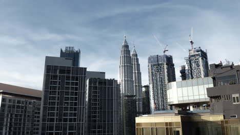 Bikini-Model-Looks-At-Petronas-Twin-Towers-From-Infinity-Pool-In-Kuala-Lumpur,-Malaysia