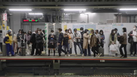 Crowd-Of-People-With-Masks-Waiting-For-The-Train-On-The-Platform-At-The-Station