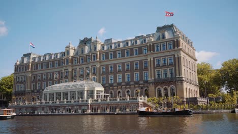 View-Of-Large-Hotel-Seen-From-Riverboat-Cruise-In-Amsterdam