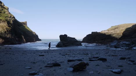 Strand-Im-Winter-Mit-Einer-Frau,-Die-Am-Meer-Spaziert