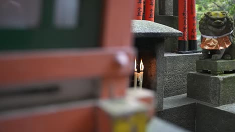 Slow-Motion-Pan-Revealing-Candles-Burning-in-Japanese-Shrine,-Fushimi-Kyoto