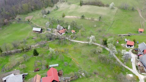 Aerial-view-of-rural-area-with-residential-houses-and-narrow-road-from-above