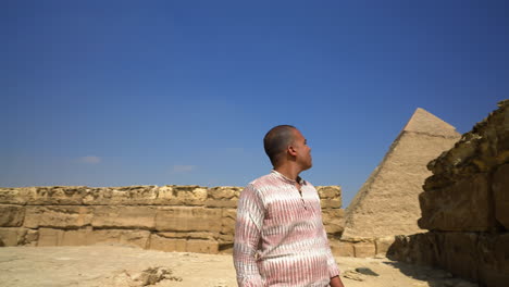 Mann-Blickt-Sich-In-Den-Pyramiden-Von-Gizeh-In-Kairo,-Ägypten-Um---Kamerafahrt