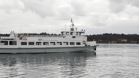 Barco-De-Cercanías-Navegando-En-Estocolmo,-Torre-De-Telecomunicaciones-Kaknas-En-Segundo-Plano