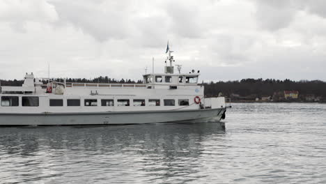 Commuter-Boat-Sailing-in-Stockholm,-Kaknas-Telecom-Tower-in-Background