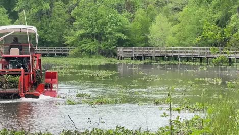 El-Cortacésped-Anfibio-Rojo-Brillante-Draga-El-Estanque-En-El-Parque-Tom-Brown-En-Tallahassee,-Fl.