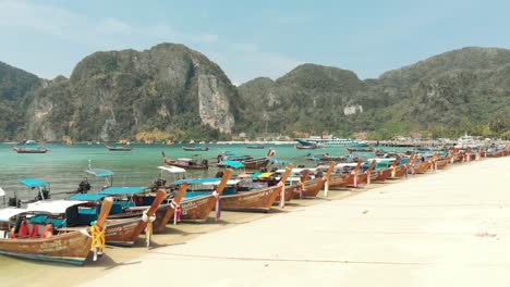 Fly-over-traditional-boats-moored-at-white-sand-beach-of-Ko-Phi-Phi-Islands