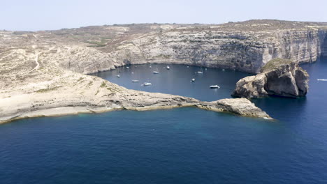 Aerial-zoom-of-yachts-anchored-in-a-hidden-Dwerja-bay,cliffs,Malta
