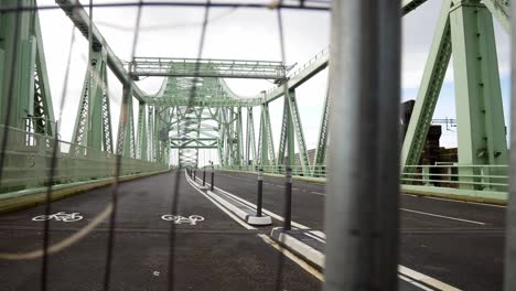 Closed-empty-unused-Runcorn-Silver-Jubilee-bridge-crossing-through-security-fence-slow-left-dolly-shot
