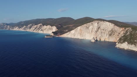 Wide-aerial-shot-revealing-the-dramatic-cliff-face-at-Porto-Katsiki,-Greece