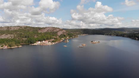 Aerial-pan-of-bay-with-rocky-islands,-beautiful-summer-sky-with-clouds