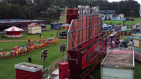 Empty-overcast-British-Silcocks-amusement-park-aerial-view-deserted-funfair-rides-low-dolly-left