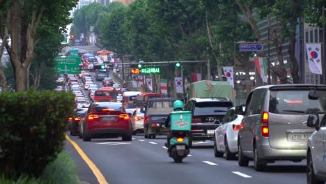 Stau-In-Der-Geschäftigen-Metropole-Seoul,-Bezirk-Gangnam,-Vorbeifahrender-Lieferroller