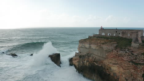 Atemberaubende-Luftaufnahme-Der-Festung-São-Miguel-Arcanjo-In-Portugal-Mit-Hohen-Wellen,-Die-Sich-Auf-Dem-Meer-Bilden-Und-Auf-Klippen-Krachen