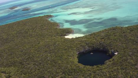 Aerial-View-of-Blue-Hole-Cenote,-Rainforest-and-Turquoise-Caribbean-Sea,-Bahamas