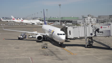 Skymark-Boeing-737-800-Connected-To-A-Jet-Bridge-From-An-Airport-Terminal-Gate-In-Tokyo,-Japan