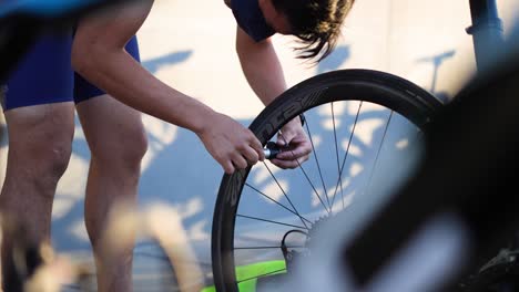 Mann-Pumpt-Fahrradreifen-Im-Triathlon-Wettbewerb-Auf