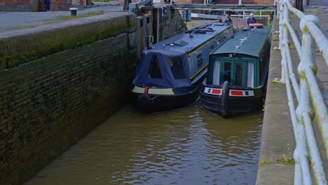 Two-canal-narrowboats-slowly-navigate-lock-system-at-Bunbury-Cheshire-alon-Shropshire-Union