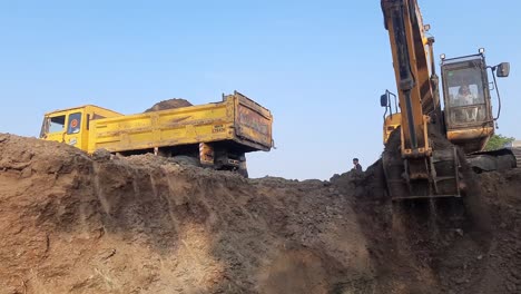 An-excavator-and-a-dumper-truck-dig-and-load-the-construction-soil