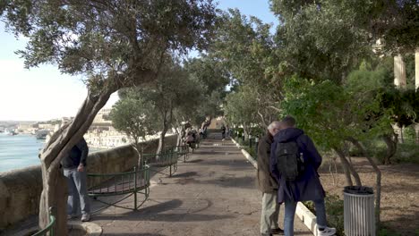 Gente-Disfrutando-De-La-Vista-Del-Puerto-Y-La-Ciudad-De-Valletta-En-La-Colina-De-Los-Jardines-Barrakka-Inferiores