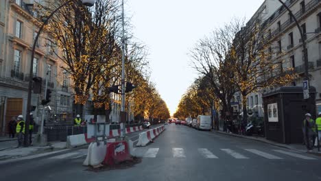 En-Un-Paseo-Rodado-En-La-Avenida-Montaigne,-Cerca-De-Los-Campos-Elíseos,-Con-Las-Luces-Navideñas-Encendidas,-Al-Final-Del-Día,-París,-Francia