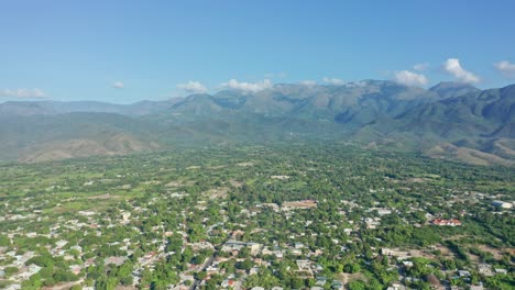 Landscape-of-Lush-Vegetation-and-Village-with-Mountains-in-the-background-in-Neiba,-Dominican-Republic---aerial-panoramic