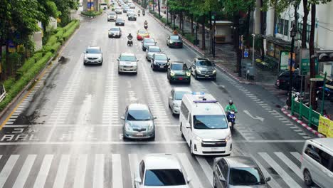 View-over-traffic-through-busy-intersections-at-rush-hour-in-Bangkok-which-is-controlled-by-traffic-lights,-there-is-heavy-traffic-every-day